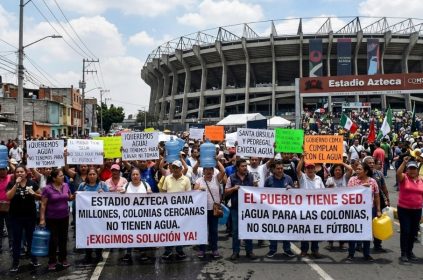 A los habitantes de la colonia Pedregal de Santa Úrsula, junto al estadio Azteca, no les han hecho justicia cuatro Mundiales de Futbol, ni los gobiernos del Partido Revolucionario Institucional, Partido de la Revolución Democrática, ni el Movimiento de Regeneración Nacional. Sus problemas de escasez de agua persisten. IMAGEN: Recreación de protestas en el Estadio Azteca con inteligencia artificial de Gemini